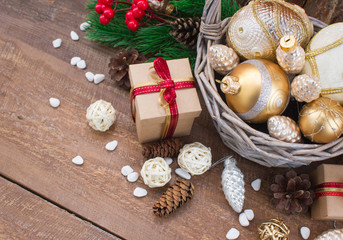 Christmas or New Year background: fur-tree branches, colorful glass balls, decoration and glittering stars on wood background