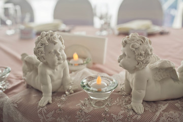 Fototapeta na wymiar two little angels stand on the table for young couple