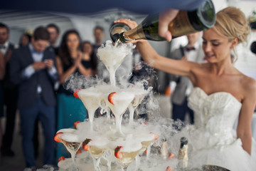 bride pours champagne for guests