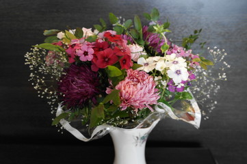 букет из садовых цветов в вазе на тёмном фоне