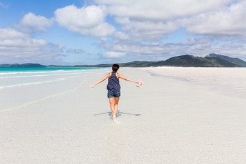 Happy running woman on beautiful beach in the Whitsunday Islands in Australia