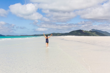 Happy running woman on beautiful beach in the Whitsunday Islands in Australia