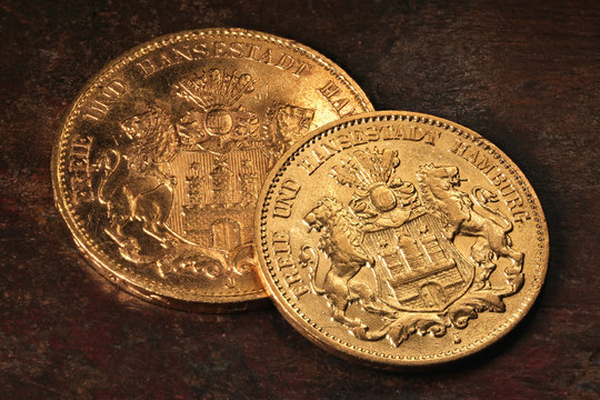 10 und 20 Reichsmark Goldmünzen (Hamburg) auf rustikalem Holztisch