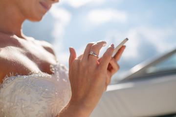 Bride is holding a phone in the wedding day