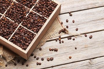 Roasted coffee beans in wooden basket on grey table