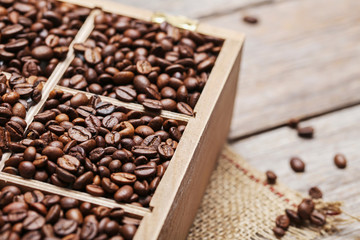 Roasted coffee beans in wooden basket on grey table