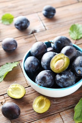 Tasty and ripe plums on brown wooden table