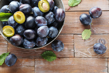 Tasty and ripe plums on brown wooden table