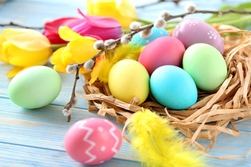 Easter eggs in nest on a blue wooden table
