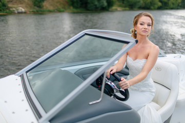 Gorgeous bride is trying to drive  a boat