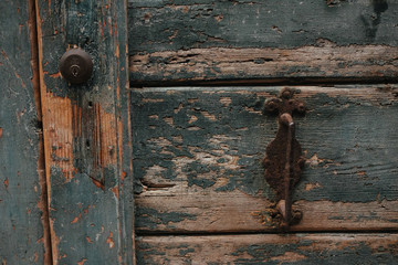 An old rusty handle on a blue door