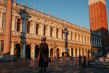 Fototapeta premium A man in the carnival costume stands on the Venice square in the