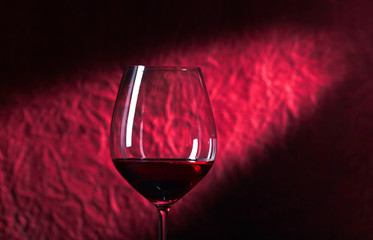 Bottle and glass of red wine on a dark  background