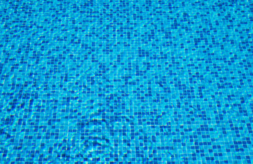 Background of a blue tiled pool with clear cool rippling water
