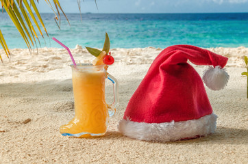 Christmas objects on the beach under a palm hat and boots of Santa