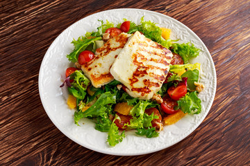 Grilled Halloumi Cheese salad witch orange, tomatoes and lettuce. healthy food