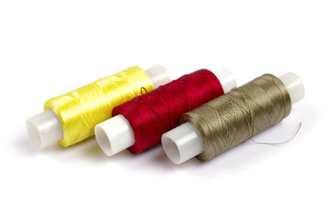 Spools of multicolored silk threads on white background