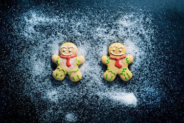 Baking Gingerbread Men for Christmas on dark table