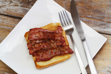 Breakfast consisting of crispy bacon on toast
