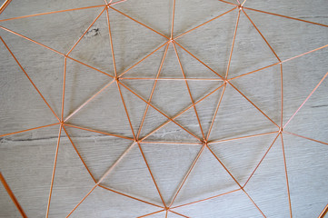 Copper geometric shape pattern on white wood background