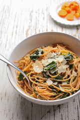 Kale, Tomato and Parmesan pasta dish vertical shot with carrots
