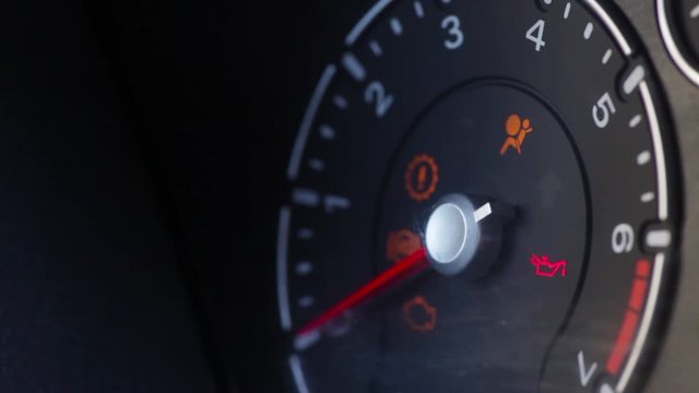 Color image of a car's oil icon lighting up on the dashboard.