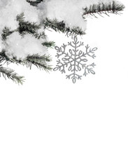 Christmas toy snowflake on the branch of fir covered with snow