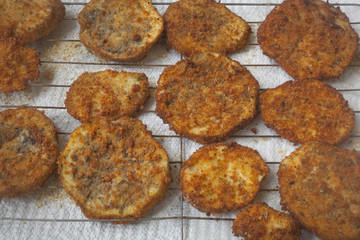 Slices of fried breaded eggplant on a tray.
