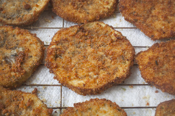 Slices of fried breaded eggplant on a tray.