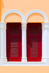 Vintage wooden red Windows and old shutters.