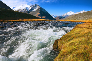 landscape of mountain peaks and swift rivers in the fall