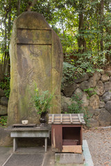 Kyoto, Japan - September 16, 2016: A stela with the chiseled picture of Quan Yin stands in a corner of the formal garden at Shorenin Buddhist Temple. Weather took its toll on the old stone. 