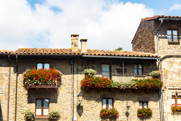 The balcony of the old stone houses decorated with flowers.