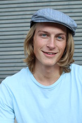 Portrait of a smiling Caucasian man in newsboy hat looking to camera