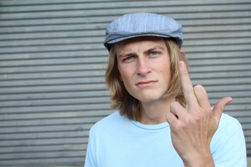 Angry male shows rude gesture on a gray background