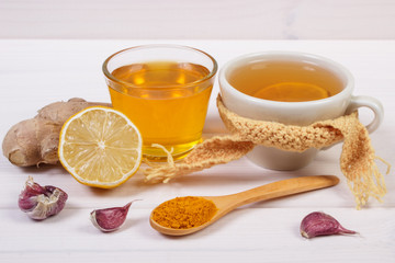 Cup of tea with lemon and ingredients for preparation warming beverage