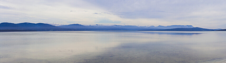 Fototapeta na wymiar Minimalistic tranquil panorama of water and mountains viewed from Bruny Island, Tasmania, Australia