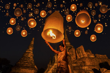 Thai woman with floating lamp in Ayuthaya historical park, with Wat Phra Sri Sanphet temple background, Thailand - obrazy, fototapety, plakaty