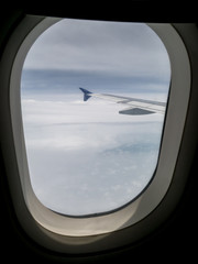 Fototapeta na wymiar View of airplane wing and blue sky from airplane window.