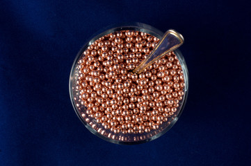 BB bullets in a glass with a teaspoon