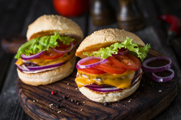 Homemade burgers on wooden cutting board. Close up, selective focus