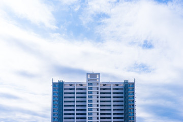 Real estate image, tower apartment building against blue sky