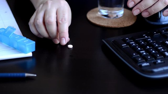 Hands get two pills out of box