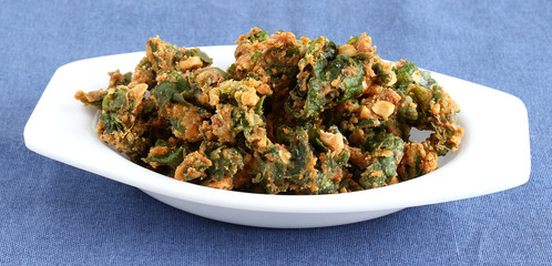 Palak pakoda, an Indian popular snack, made from deep frying portions of the batter of palak or spinach and chickpea flour.