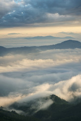 Fototapeta premium High mountain ridge in the clouds during sunrise. Beautiful panoramic landscape..