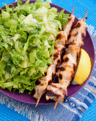 Chicken skewers with salad with green salad. Vertical shot