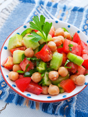 Salad with tomatoes, cucumbers and chickpeas. Vertical shot