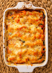 Baked chicken fillets with mozzarella in casserole. Shot from ab