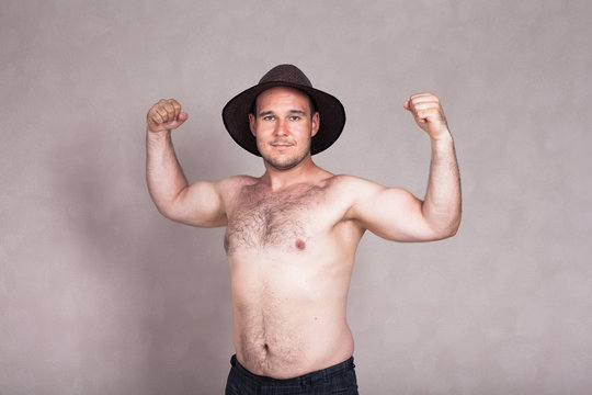 Shirtless man in hat posing and showing his strong body