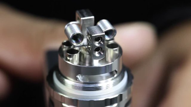 test burning the new dual kanthal micro coils on the atomizer’s deck base of electronic cigarette for vaping, close up scene, high definition, Full HD, 1920x1080